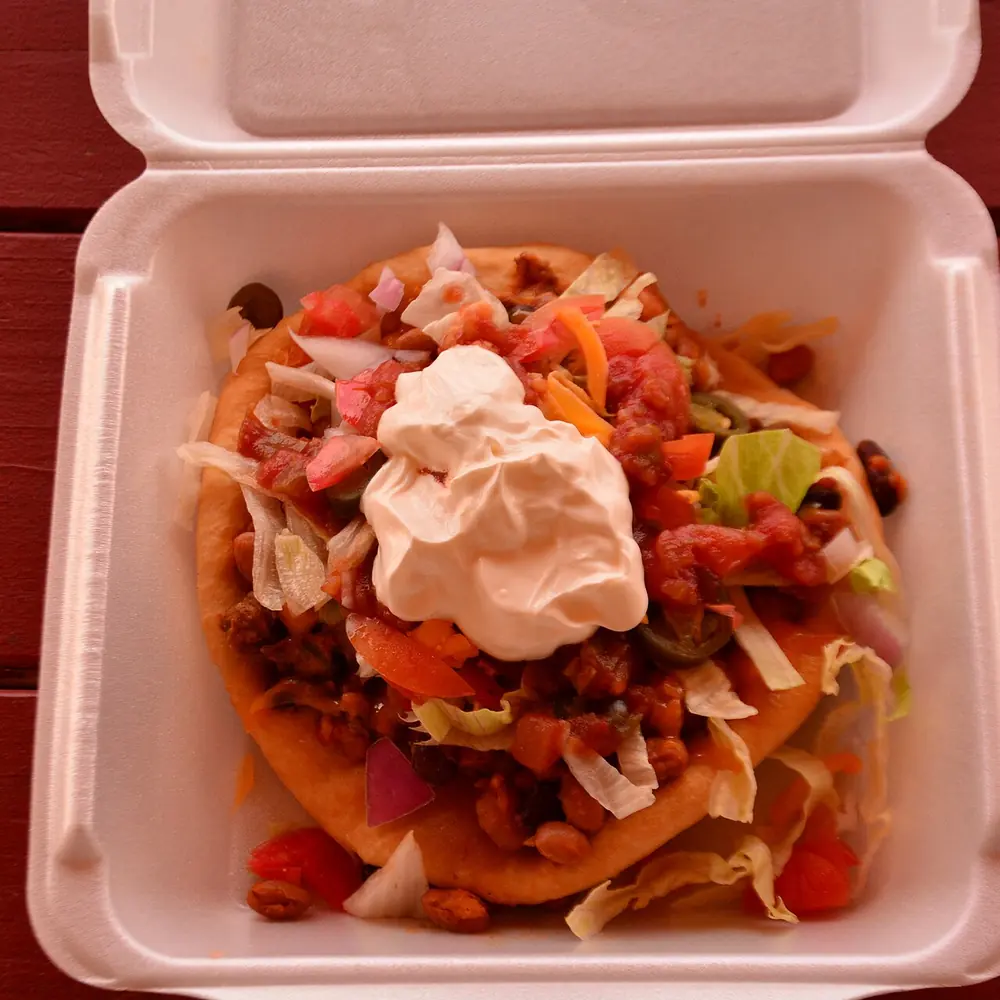 A Navajo taco on fry bread with lettuce, tomato, beans and sour cream, photographed at another restaurant.